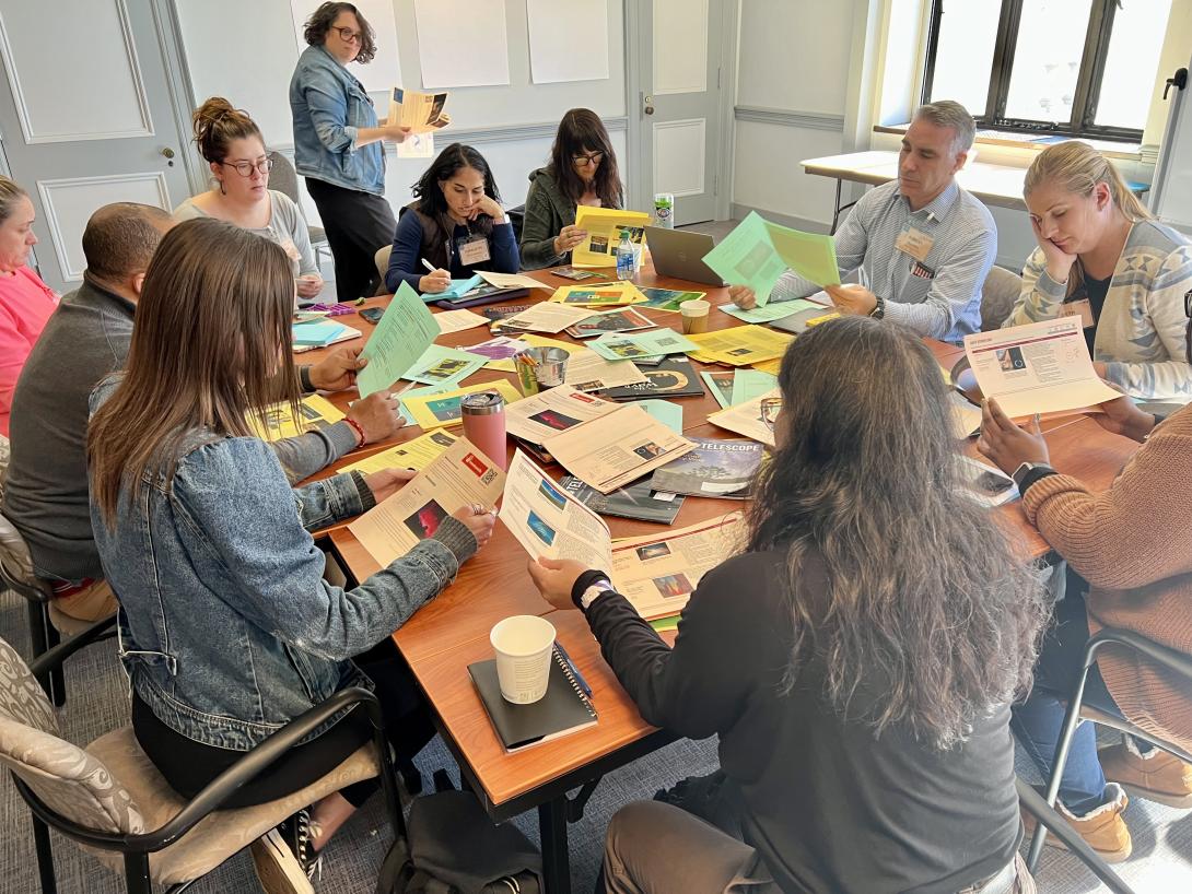 Educators gathered around a table engaged in co-creation work